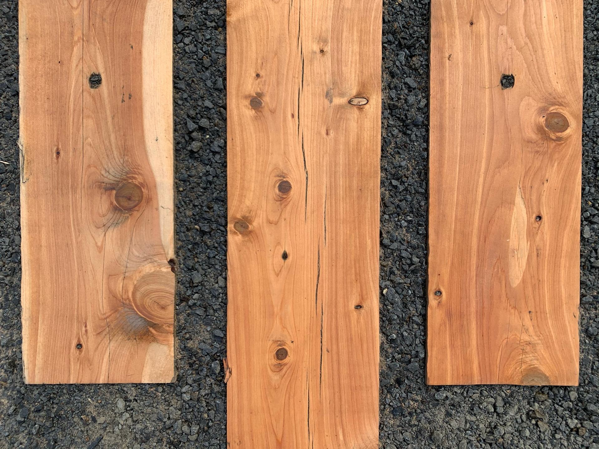 Three wooden planks laid on gravel, symbolizing building and collaboration.
